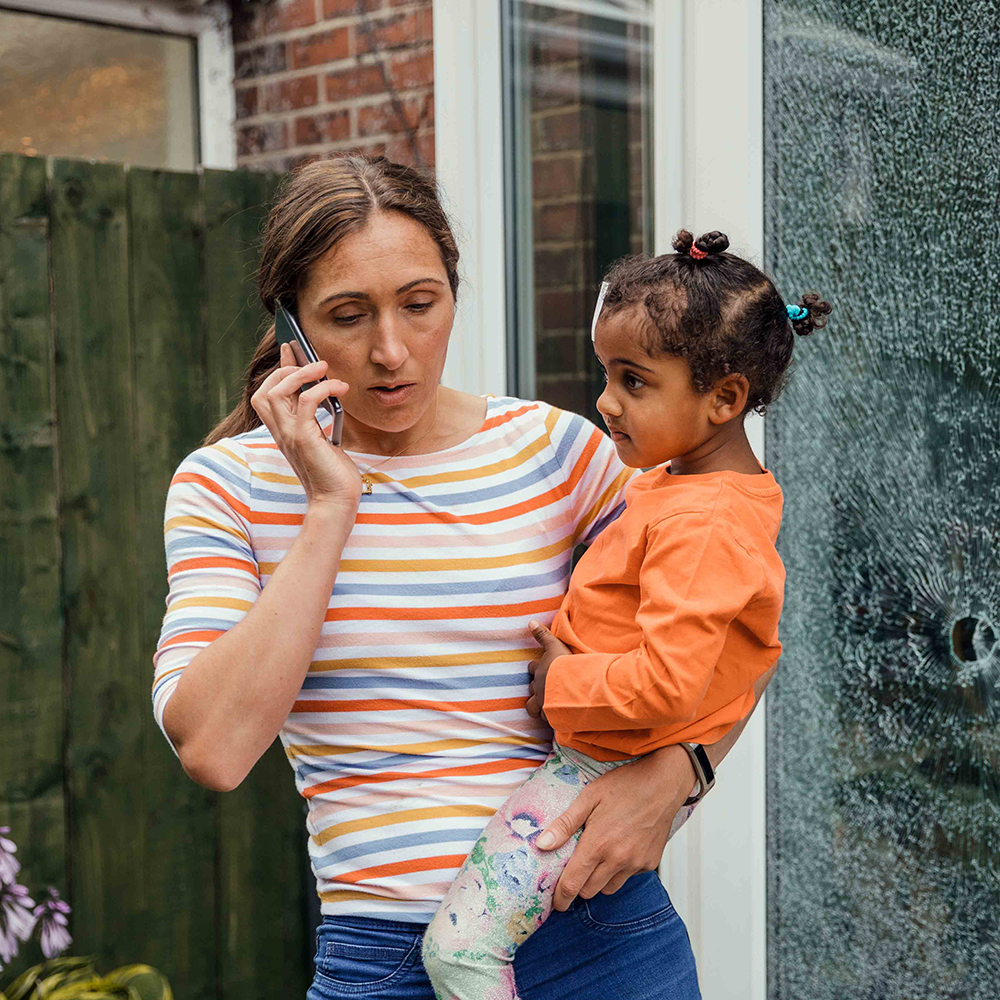 Mother holding child while talking on phone